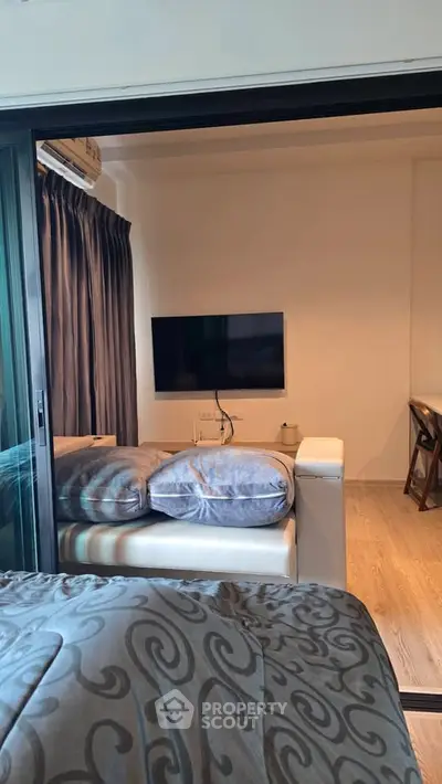 Modern living room with cozy sofa and wall-mounted TV, perfect for relaxation and entertainment.