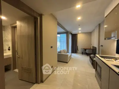 Modern open-layout living room with kitchen and cozy seating area in a stylish apartment.