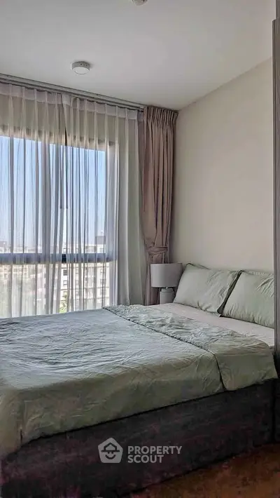 Cozy bedroom with large window and elegant curtains in modern apartment