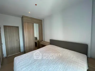 Spacious bedroom with modern wooden wardrobe and large bed in a minimalist design.