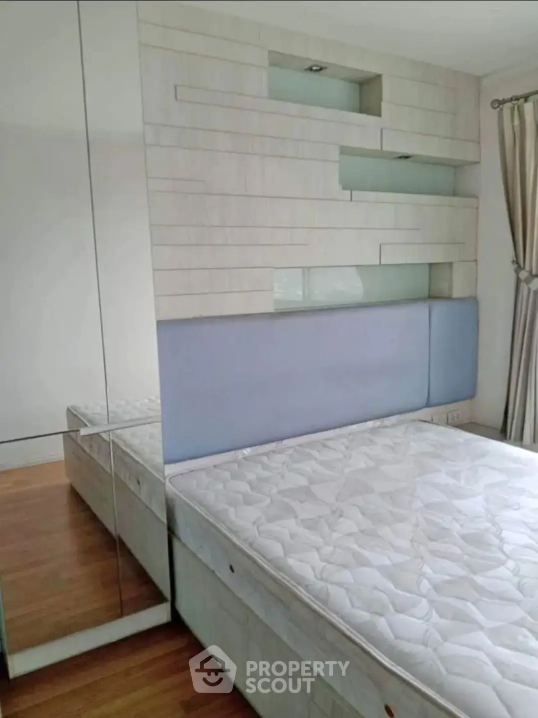 Modern bedroom with stylish wall paneling and mirrored wardrobe