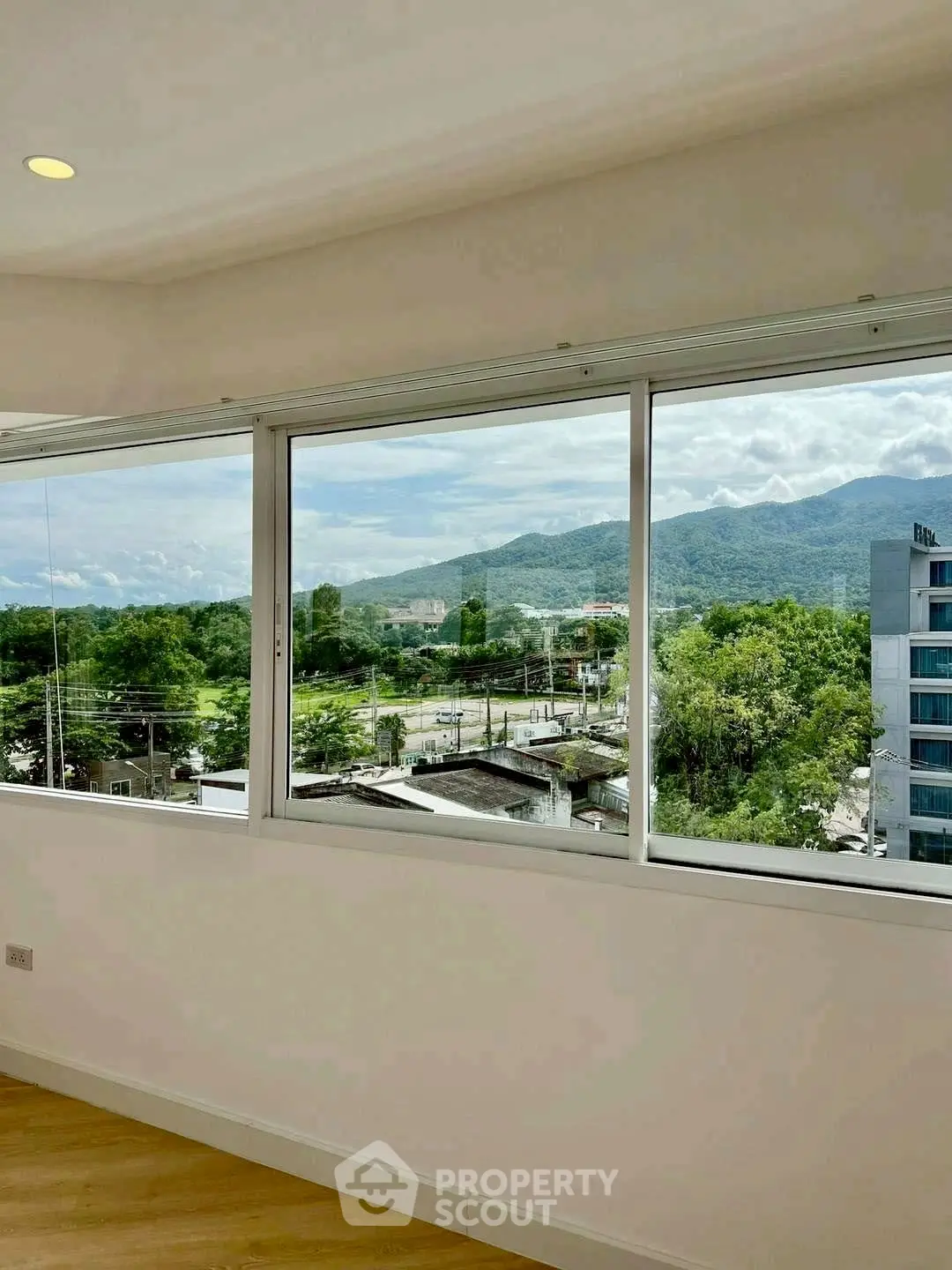 Spacious room with large windows offering stunning mountain views, perfect for a serene living experience.