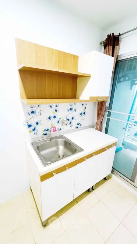 Compact kitchen with modern sink and floral backsplash, perfect for small spaces.