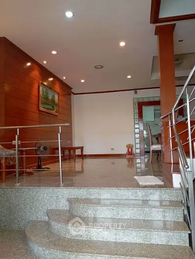 Elegant split-level living area with modern lighting and polished stone flooring