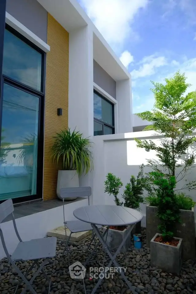 Modern outdoor patio with sleek furniture and lush greenery, perfect for relaxation and entertaining.
