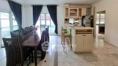 Spacious kitchen with elegant dining area and pool view, perfect for family gatherings.