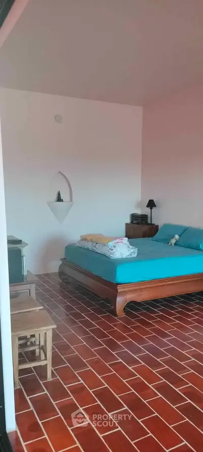 Charming bedroom with rustic terracotta flooring and elegant wooden bed frame.