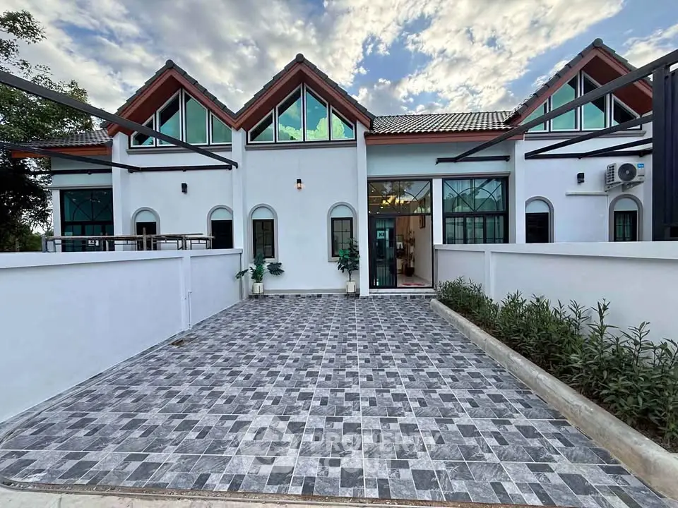 Charming townhouse with modern facade and spacious driveway, perfect for family living.