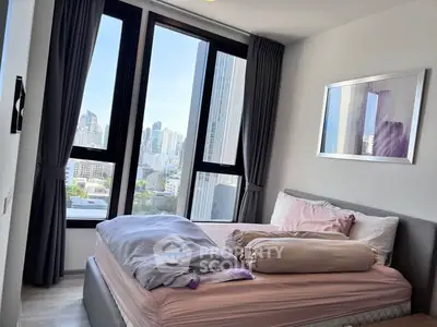 Modern bedroom with large windows offering stunning city views in a high-rise apartment.