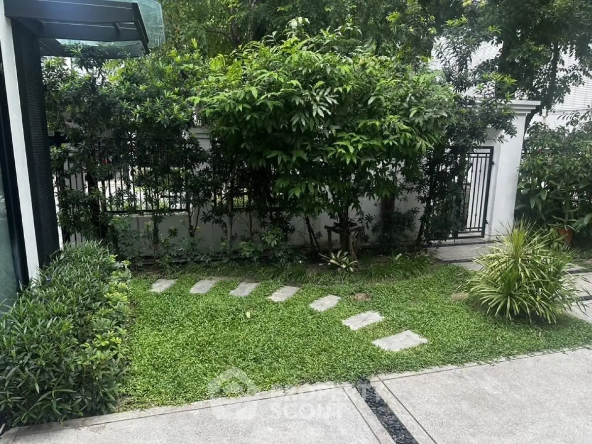 Charming garden view with lush greenery and stepping stones in a serene residential setting.