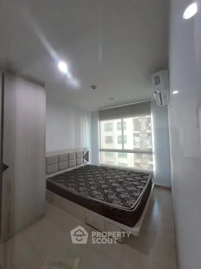 Modern bedroom with large window and stylish bed in a contemporary apartment.