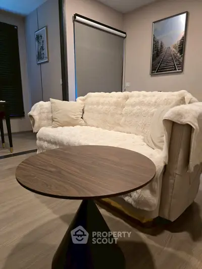 Cozy living room with plush sofa and modern round table, perfect for relaxation.