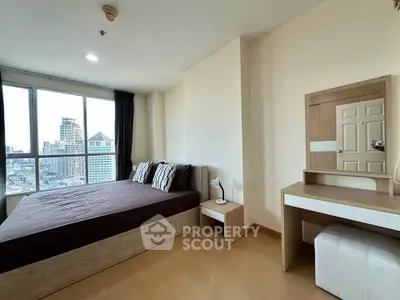 Spacious bedroom with city view, featuring modern furniture and large windows for natural light.