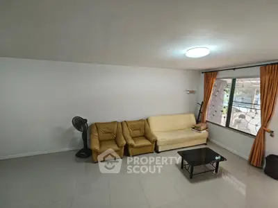 Spacious living room with modern furniture and large window for natural light.