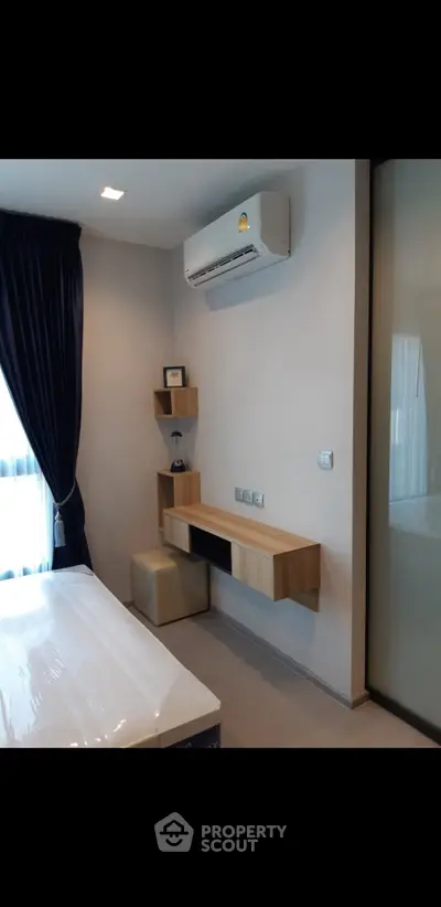 Modern bedroom with air conditioning and stylish shelving, perfect for comfort and functionality.