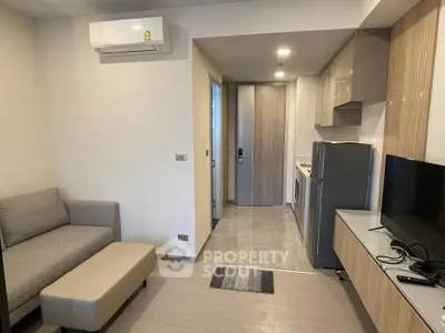 Modern apartment interior with sleek kitchen and cozy living area, featuring air conditioning and contemporary design.