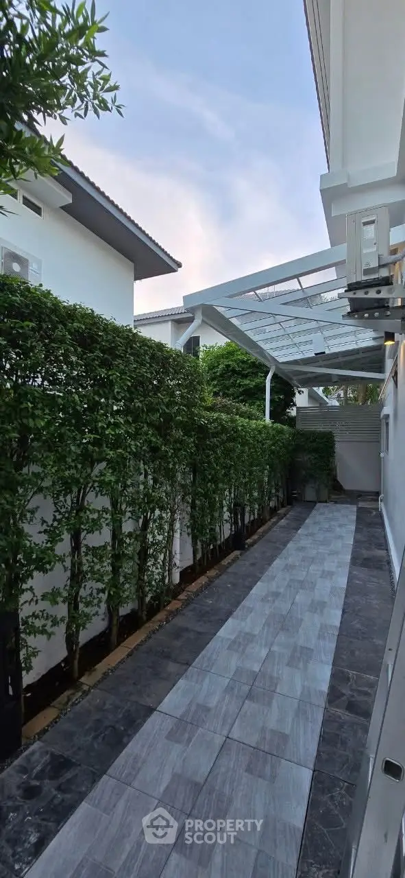 Charming exterior walkway with lush greenery and modern design
