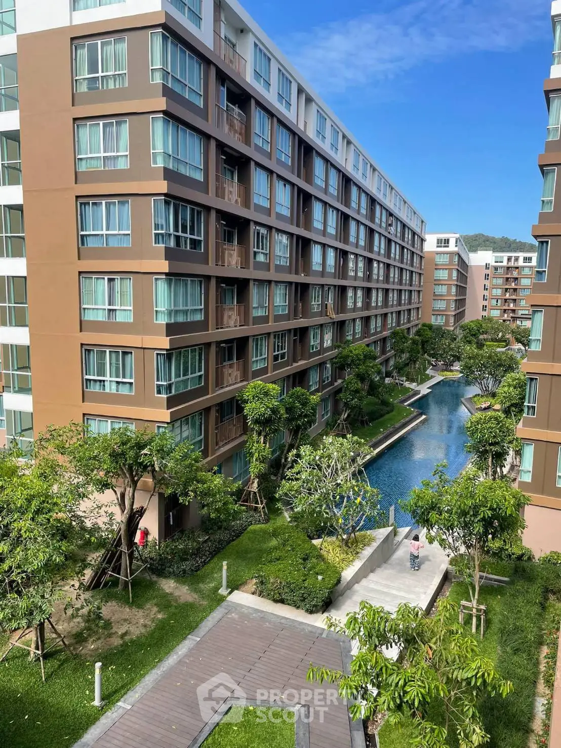 Modern apartment complex with lush gardens and serene pool view