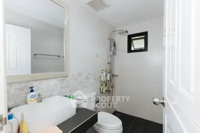 Modern bathroom with sleek fixtures and neutral tones, featuring a shower and stylish vanity.
