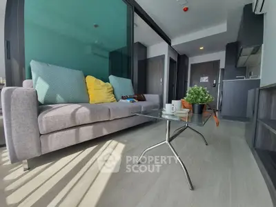 Modern living room with stylish sofa and glass coffee table in a bright apartment.
