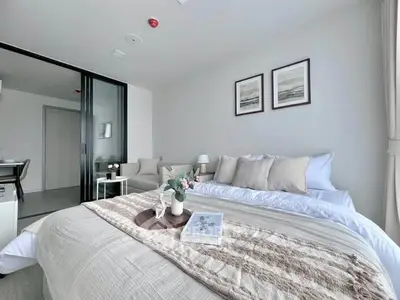 Modern bedroom with elegant decor and sliding glass doors leading to a cozy living area.