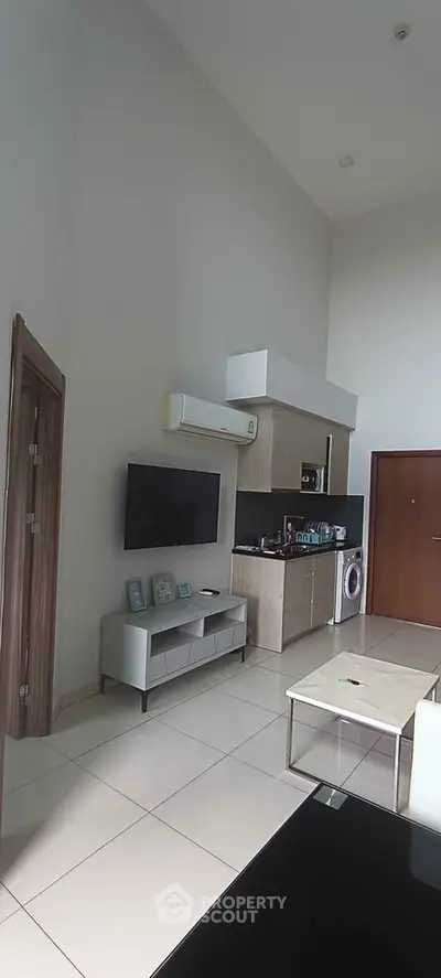 Modern living room with sleek kitchen appliances and minimalist decor