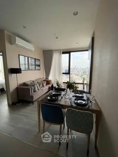 Modern living room with dining area and city view, featuring stylish decor and natural light.