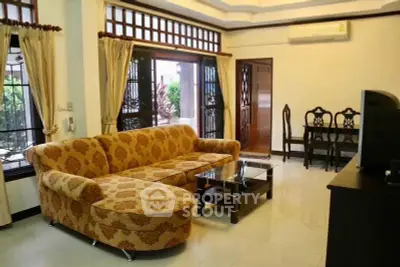 Spacious living room with elegant sofa and dining area in a cozy home.