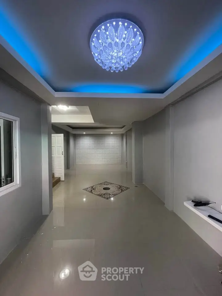 Spacious modern interior with elegant lighting and sleek tile flooring, perfect for stylish living.
