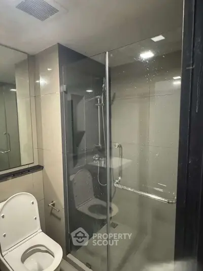Modern bathroom with glass shower enclosure and sleek fixtures.