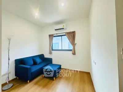 Cozy living room with blue sofa and natural light, perfect for relaxation.