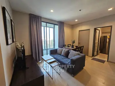 Modern living room with balcony access and stylish furniture in a cozy apartment.