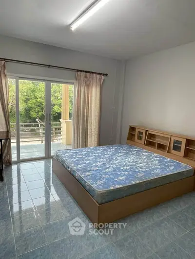 Spacious bedroom with balcony access and serene view