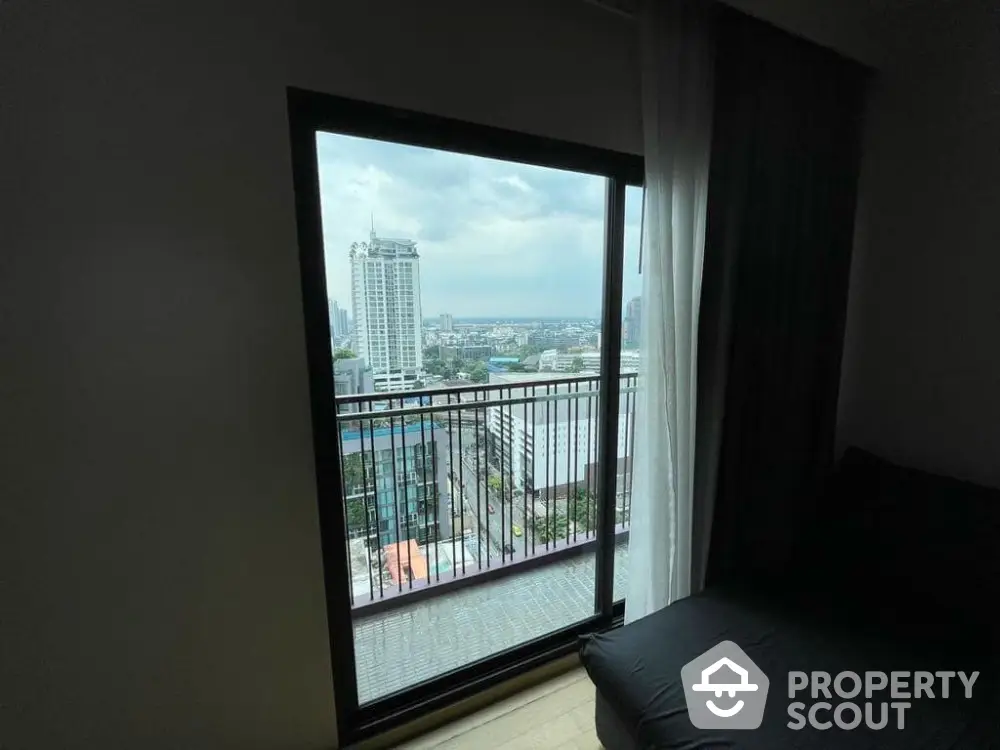 Stunning city view from high-rise apartment balcony with floor-to-ceiling window.