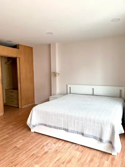 Spacious bedroom with wooden flooring and built-in wardrobe