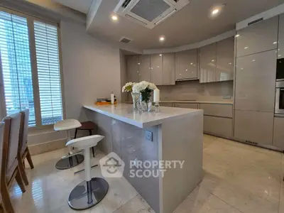 Modern kitchen with sleek cabinetry and breakfast bar in luxury apartment