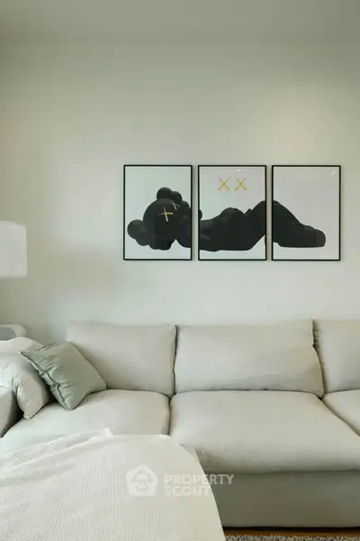 Modern living room with stylish artwork and cozy beige sofa, perfect for relaxation and contemporary living.