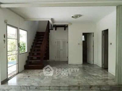 Spacious interior with marble flooring and wooden staircase in modern home