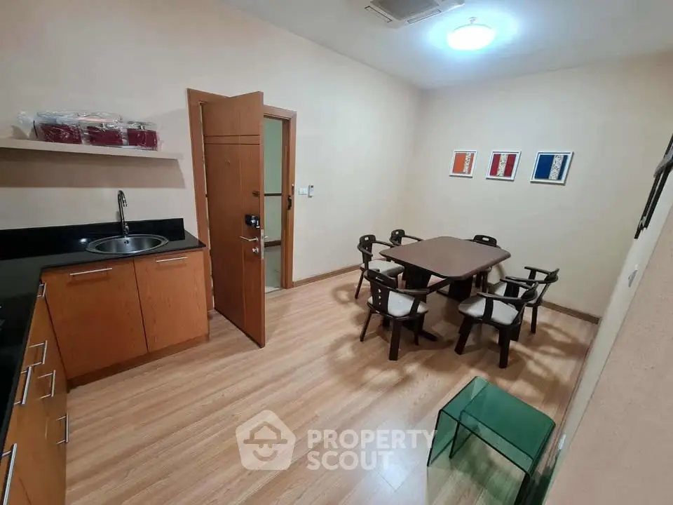 Spacious kitchen with dining area featuring modern wooden cabinets and stylish decor.