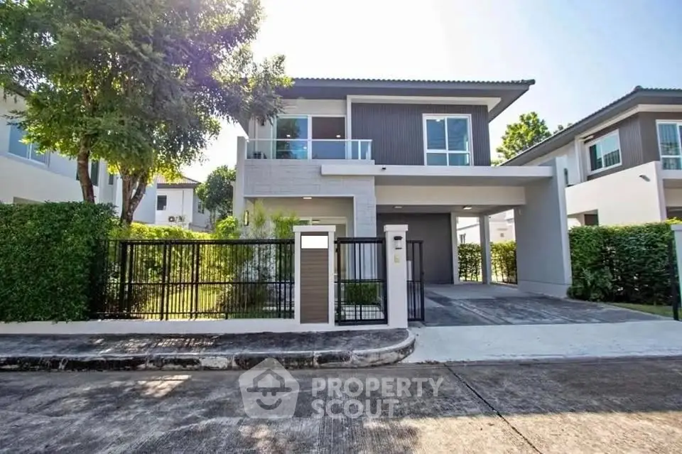 Modern two-story house with sleek design and spacious driveway in a serene neighborhood.