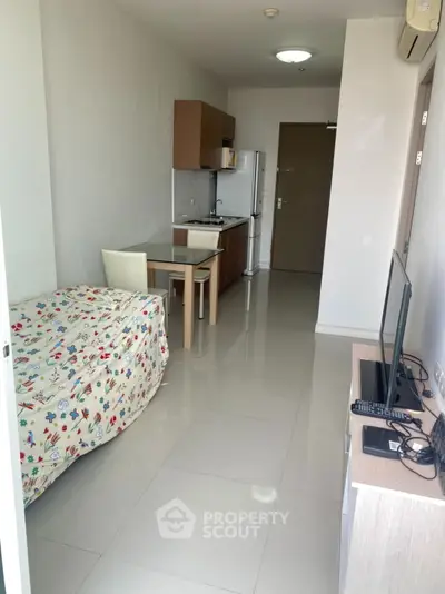 Modern studio apartment with compact kitchen and cozy living area, ideal for urban living.