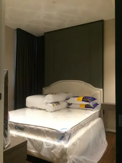 Cozy bedroom with new mattress and pillows, featuring elegant dark curtains and modern decor.