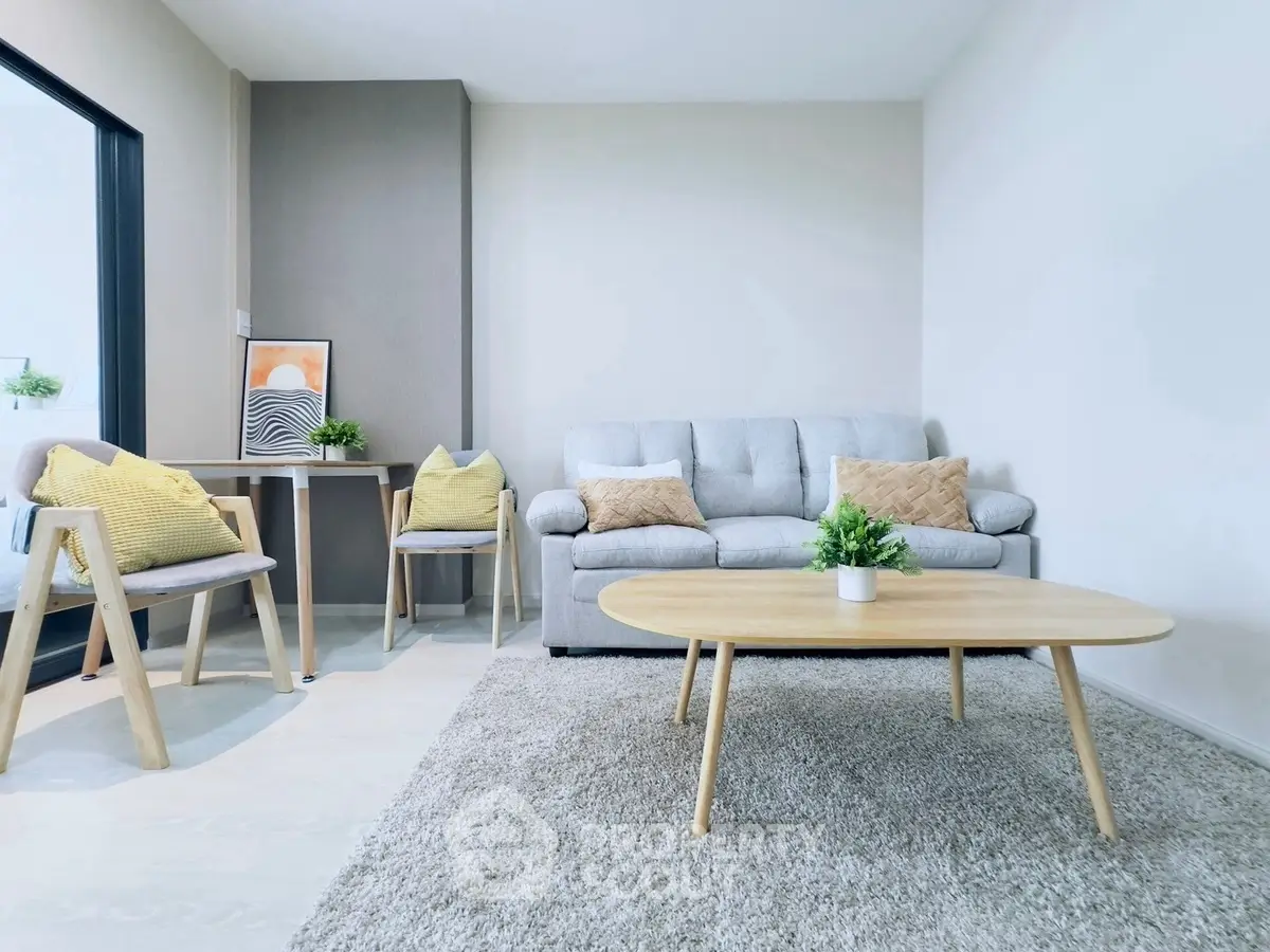 Modern living room with cozy sofa, stylish decor, and light wood furniture