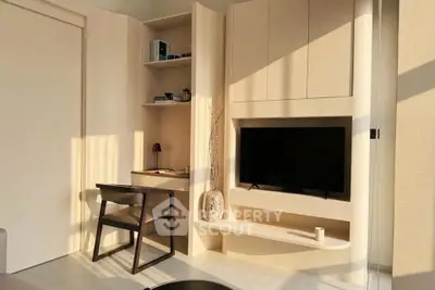 Modern living room with built-in TV unit and study desk, featuring sleek design and natural lighting.
