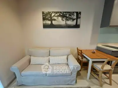 Cozy living room with a comfortable sofa and dining area, perfect for relaxation and dining.