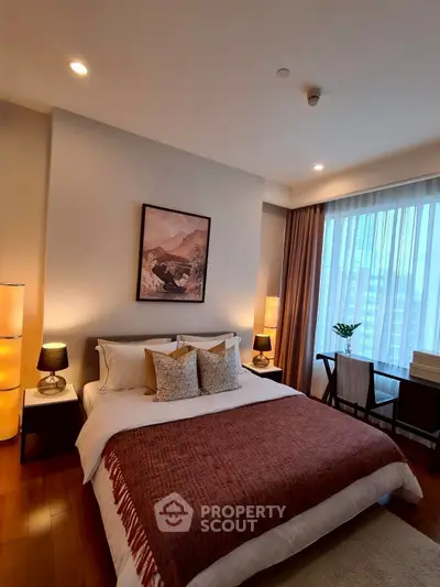 Luxurious bedroom with elegant decor and large window offering city views.