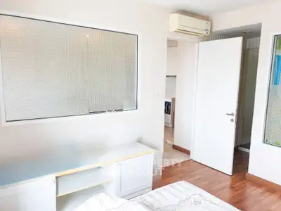 Bright bedroom with air conditioning and wooden flooring in modern apartment.