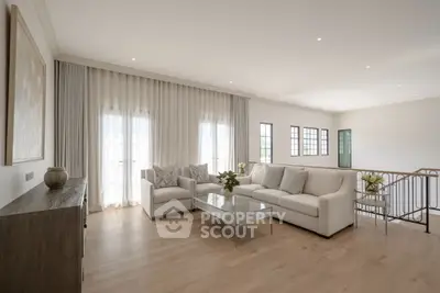 Elegant living room with modern decor, large windows, and cozy seating area.