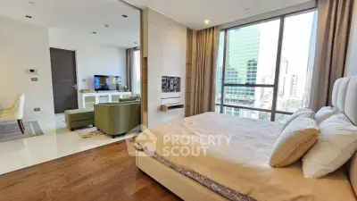 Luxurious modern bedroom with city view and adjacent living area in high-rise apartment.