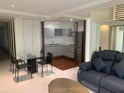 Modern open-layout living room and kitchen with sleek furniture and stylish decor.